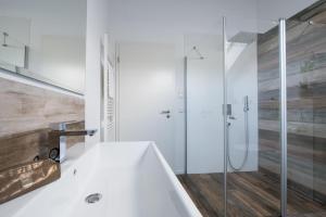 a white bathroom with a tub and a shower at Schiff in Gelting