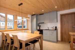 eine Küche und ein Esszimmer mit einem Holztisch und Stühlen in der Unterkunft Ferienchalet Sonne in Adelboden