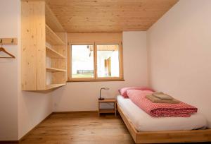 a small bedroom with a bed and a window at Ferienchalet Sonne in Adelboden