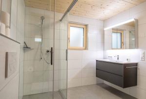 uma casa de banho com uma cabina de duche em vidro e um lavatório. em Ferienchalet Sonne em Adelboden