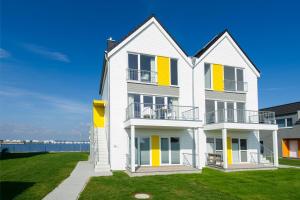 a large white house with yellow shutters at Maine in Olpenitz