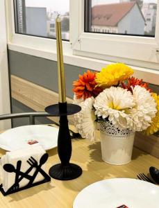 a table with a black vase and flowers on it at Welcoming Central Studio with self check in in Bucharest