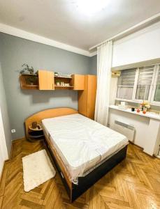 a bedroom with a bed in the corner of a room at Welcoming Central Studio with self check in in Bucharest