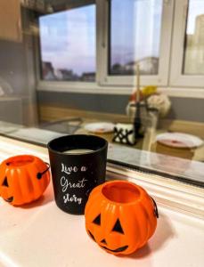 a coffee cup and two pumpkins on a counter at Welcoming Central Studio with self check in in Bucharest