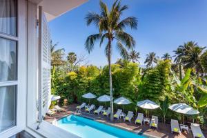 ルアンパバーンにあるHomm Souvannaphoum Luang Prabang, part of Banyan Groupの屋外スイミングプール(椅子、パラソル付)