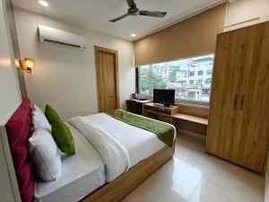 a bedroom with a bed and a window with a television at Hotel Utsav Grand in Varanasi