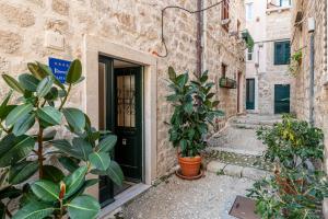 an alley with a black door and some plants at Villa Mirabilis, stunning superior villa, Dubrovnik Old Town in Dubrovnik