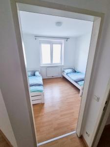 a mirror in a room with two beds and a window at ADSA Apartment Linz in Linz
