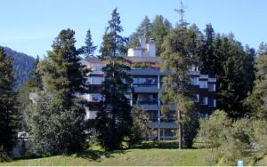 ein großes Apartmenthaus inmitten von Bäumen in der Unterkunft Lac 16 in St. Moritz