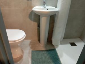 a bathroom with a white sink and a toilet at BluejSuite in Ayia Napa