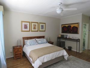 Avo Tree Guesthouse في بارل: غرفة نوم بسرير ومروحة سقف