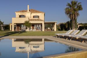 a villa with a swimming pool in front of a house at Porto Heli - Heaven on Earth Villa in Ermioni