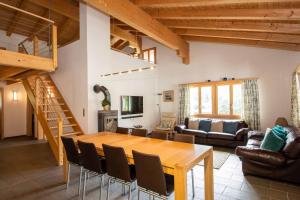 a living room with a wooden table and chairs at Ferienwohnung Schützenrain DG in Adelboden