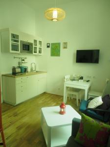 a living room with a couch and a table and a kitchen at Nähe Naschmarkt in Vienna