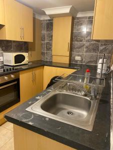 a kitchen with a sink and a microwave at Circle Guest House Bed Only in Southampton