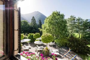 a view from a window of a patio with tables and umbrellas at Romantik Hotel & Restaurant Stafler in Vipiteno