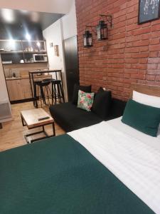 a bedroom with a large bed and a brick wall at Apartamenty Prosta - Podmurna in Toruń