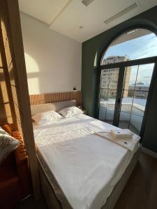 a bedroom with a large bed with a large window at Aygestan plaza apartment 5 in Yerevan