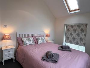 a bedroom with a pink bed with towels on it at 3 Bed in Langtree 58822 in Langtree