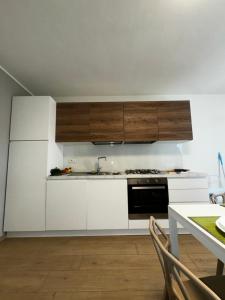 a kitchen with white cabinets and a black oven at Villa Gina Case Vacanze in Roseto degli Abruzzi