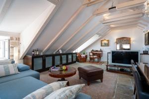 a living room with a blue couch and a tv at Villa Mirabilis, stunning superior villa, Dubrovnik Old Town in Dubrovnik