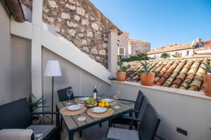 uma mesa com comida e bebidas numa varanda em Villa Mirabilis, stunning superior villa, Dubrovnik Old Town em Dubrovnik