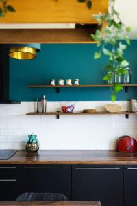 een keuken met blauwe muren en een houten aanrecht bij Grand Appartement 4 Pièces à 10min Paris (80m2) in Vitry-sur-Seine