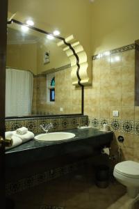 a bathroom with a sink and a toilet and a mirror at Heritage Resort Bikaner in Bikaner