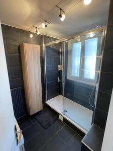 uma casa de banho com um chuveiro e uma cabina de duche em vidro. em Grand Appartement 4 Pièces à 10min Paris (80m2) em Vitry-sur-Seine