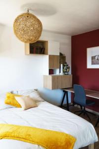 um quarto com uma cama com um cobertor amarelo e uma secretária em Grand Appartement 4 Pièces à 10min Paris (80m2) em Vitry-sur-Seine