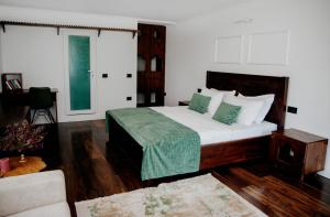 a bedroom with a bed with green and white pillows at Hotel Thethi in Theth