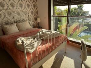 a bedroom with a bed and a large window at Villa 96 Taghazout Bay in Taghazout