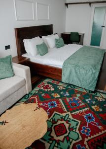 um quarto com uma cama, um sofá e um tapete em Hotel Thethi em Theth