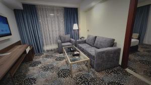 a living room with a couch and a tv in a hotel room at Castle Hotel in Medina