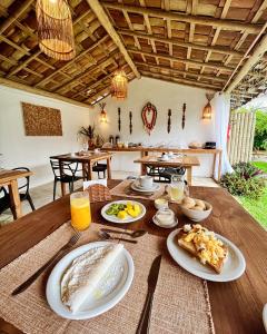 uma mesa de madeira com pratos de comida em Casa Roure Pousada em Trancoso