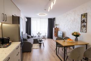 eine Küche und ein Wohnzimmer mit einem Tisch und einem Sofa in der Unterkunft New Modern & Cozy apartment with free parking in Warna