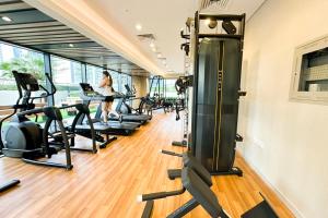 un gimnasio con máquinas de correr y una mujer de fondo en Elegant Studio at Damac Celestia, Dubai south - Ezytrac vacation Homes, en Dubái