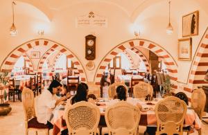 a group of people sitting at a table in a restaurant at Tuya Abu Simbel Hotel in Abu Simbel