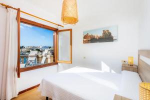 a bedroom with a window with a view of a boat at Casa Michaela in Santanyi