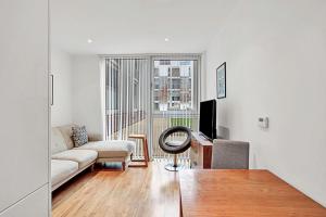 a living room with a couch and a television at Urban Retreat Stylish 1-Bed Bliss in London