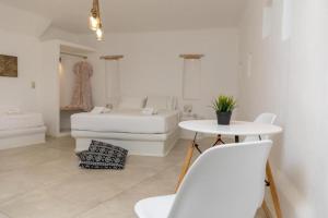 a white living room with a table and a couch at Ampelos Prokopios in Agios Prokopios +32 photos