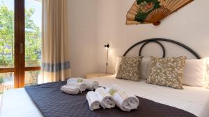 - une chambre avec un lit et des serviettes dans l'établissement Luisa Sunny House, à Santa Maria Navarrese