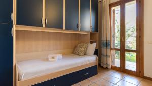 - un petit lit dans une chambre avec fenêtre dans l'établissement Luisa Sunny House, à Santa Maria Navarrese