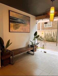 um quarto com um banco e uma pintura na parede em Airy Apartment w/ Pool + Gym em Nairobi