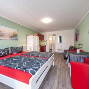 a bedroom with a large bed and a living room at Großer Gartenbungalow Nr 3 mit Terrasse - Strandvogtei Sellin in Ostseebad Sellin