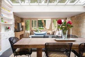 comedor y sala de estar con mesa y sillas en Elegant Paddington Sandstone Cottage with Parking en Sídney