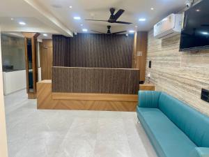 a lobby with a blue couch and a large screen at Hotel Royal Elite in Rajkot +16 photos