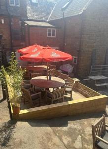 a patio with a table and umbrella and chairs at Bartholomew Arms in Northampton