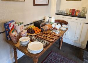 una mesa de madera con comida y platos. en Bartholomew Arms, en Northampton
