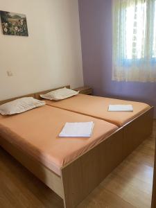 twee bedden in een kamer met twee handdoeken erop bij Apartments Silvana in Rogoznica